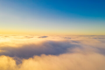 Aerial images of clouds from thick fog in the rays of the dawn sun in autumn at high altitude