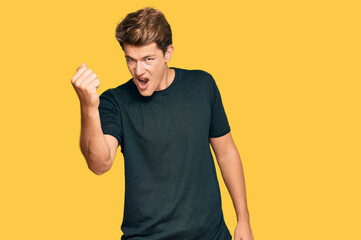 Handsome caucasian man wearing casual clothes angry and mad raising fist frustrated and furious...