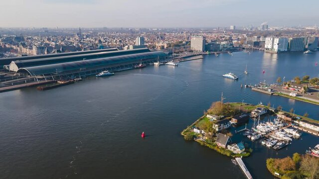 Aerial view hyperlapse of Amsterdam Central The Netherlands ferries fly over drone shot of skyline