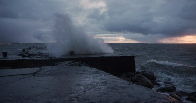 Stormy weather strong wind waves crashing to the pier in slow motion
