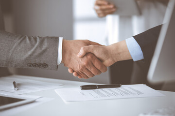 Obraz premium Business people shaking hands finishing contract signing, close-up. Business communication concept. Handshake and marketing