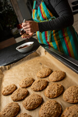 pregnant women is coating cookies with chocolate