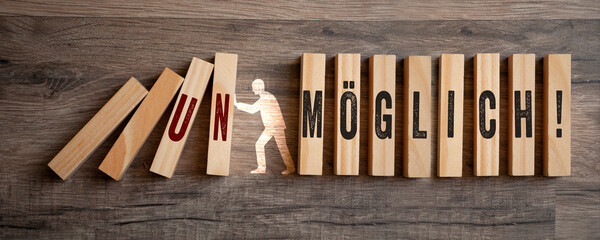 Pieces of wood with the german words for impossible and possible - möglich unmöglich on wooden...