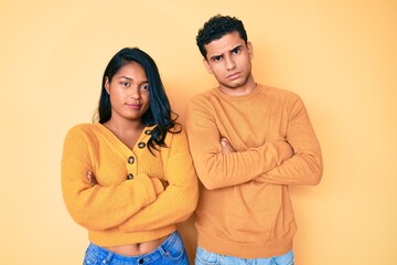 Fototapeta premium Beautiful latin young couple wearing casual clothes together skeptic and nervous, disapproving expression on face with crossed arms. negative person.
