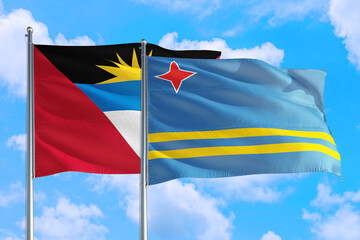 Aruba and Antigua and Barbuda national flag waving in the windy deep blue sky. Diplomacy and international relations concept.