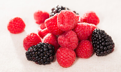 handful of fresh raspberry and blackberry berries on white background