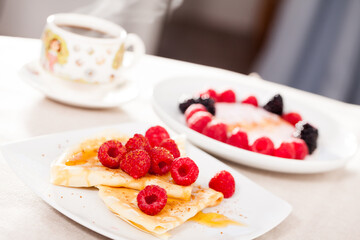 breakfast of pancakes with fresh raspberries on table