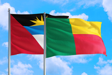Benin and Antigua and Barbuda national flag waving in the windy deep blue sky. Diplomacy and international relations concept.