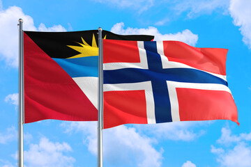 Bouvet Islands and Antigua and Barbuda national flag waving in the windy deep blue sky. Diplomacy and international relations concept.