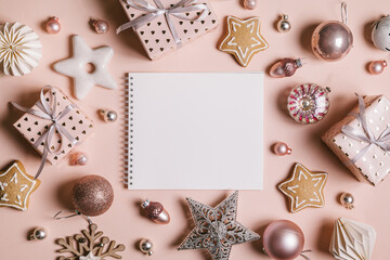 Christmas composition. Frame with gingerbread, gifts, Christmas decorations and an empty sheet for text on pastel pink background.