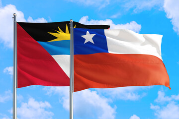 Chile and Antigua and Barbuda national flag waving in the windy deep blue sky. Diplomacy and international relations concept.