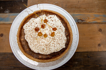 A delicious desert cake of a Bonfire Toffee and Hazelnut tart on a wooden kitchen work top