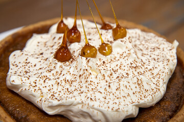 A delicious desert cake of a Bonfire Toffee and Hazelnut tart on a wooden kitchen work top