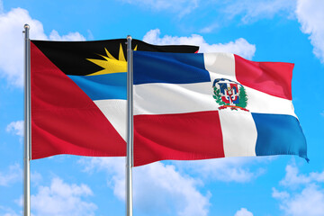 Dominican Republic and Antigua and Barbuda national flag waving in the windy deep blue sky. Diplomacy and international relations concept.