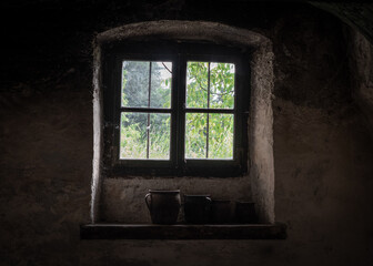 Fototapeta na wymiar The window and clay jugs on windowsill old farmhouse