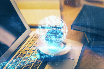 Multi exposure of blockchain and crypto economy theme hologram and table with computer background....