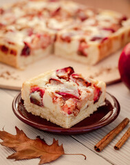 a piece of apple pie with creamy filling cutting into squares close up