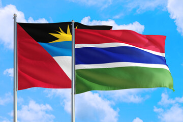 Gambia and Antigua and Barbuda national flag waving in the windy deep blue sky. Diplomacy and international relations concept.