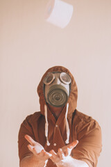 Blurred man in gas mask catches falling toilet paper