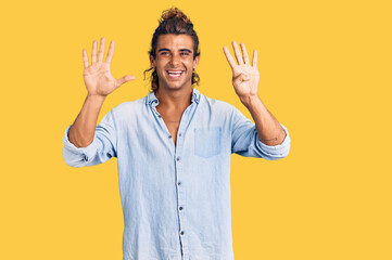 Young hispanic man wearing summer style showing and pointing up with fingers number nine while...