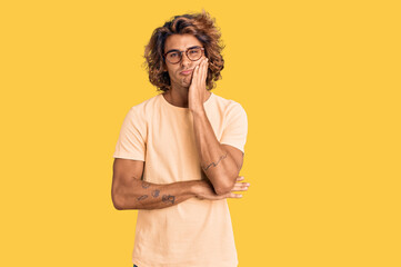 Young hispanic man wearing casual clothes and glasses thinking looking tired and bored with...