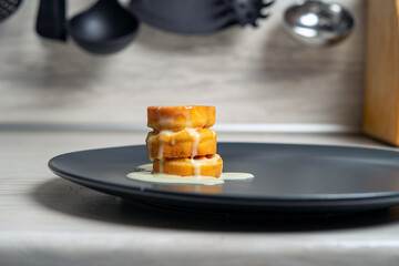Two soft round waffles with condensed milk in blue saucer on wooden table.