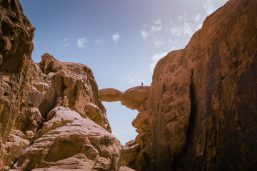 Bedouin guide on the bridge-shaped rock formation in the Wadi Rum desert in Jordan