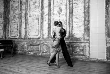 beautiful couple with dance costumes dancing latin dances in the hall