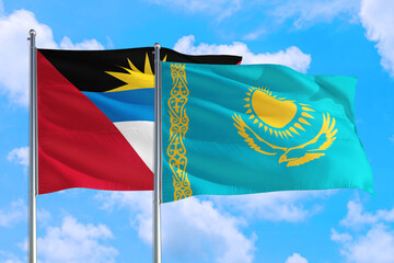 Kazakhstan and Antigua and Barbuda national flag waving in the windy deep blue sky. Diplomacy and international relations concept.