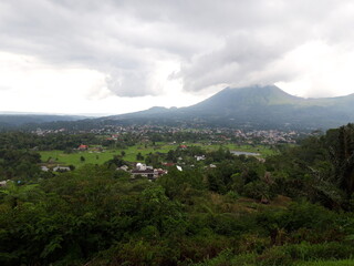 Fototapeta premium Beautiful Scenery of Countryside Village Below the Mountain at Cloudy Weather