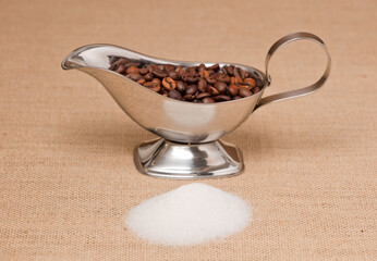 Fototapeta premium pile of sugar and silver container with coffee, on raffia cloth