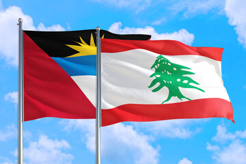 Lebanon and Antigua and Barbuda national flag waving in the windy deep blue sky. Diplomacy and...