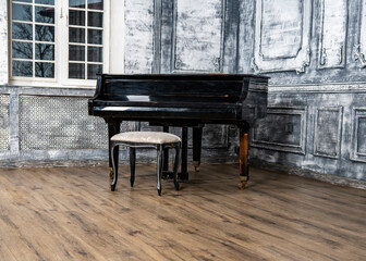 vintage black grand piano in the dance hall in gray tones