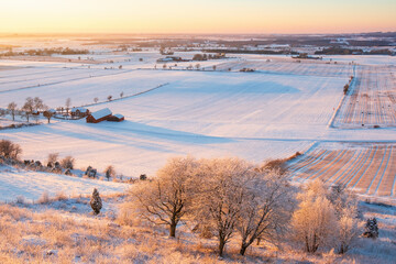 Sunset in winter at a rural landscape with snow and frost