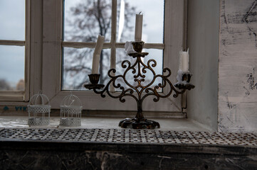antique candlestick with candles in a large gray hall