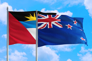 New Zealand and Antigua and Barbuda national flag waving in the windy deep blue sky. Diplomacy and international relations concept.