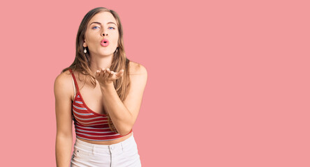 Beautiful caucasian young woman wearing casual clothes looking at the camera blowing a kiss with hand on air being lovely and sexy. love expression.