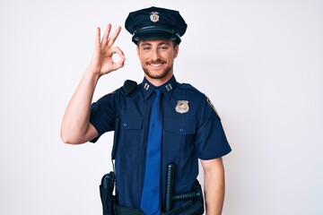 Young caucasian man wearing police uniform smiling positive doing ok sign with hand and fingers. successful expression.