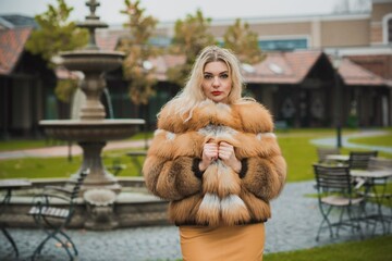 Gorgeous plus size blonde European woman in luxury fur coat, women's beauty. Concept of furs