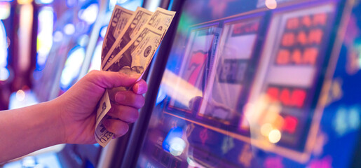 Slot Machine Play Time. Female Gambler Hand hold money bill ready to win the game with one best...