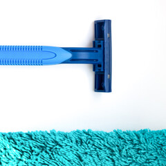 The razor lies near a green towel,