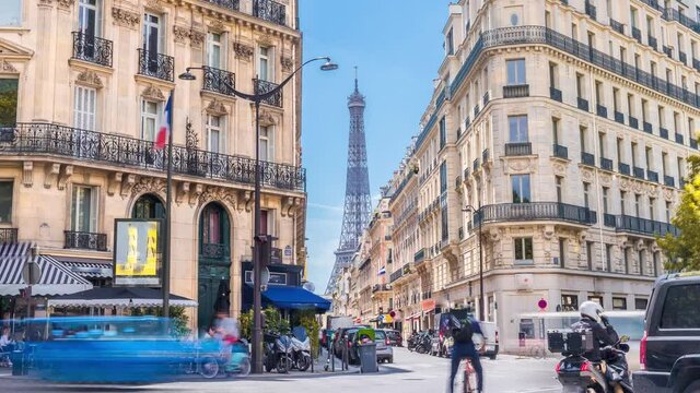 Romantic cozy view of the famous Eiffel tower from a small paris street on a cloudy autumn day with yellow gloden leaves - wide horizontal panorama.Camera zooms out