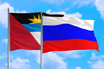 Fototapeta na wymiar Russia and Antigua and Barbuda national flag waving in the windy deep blue sky. Diplomacy and international relations concept.
