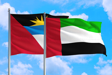 Fototapeta premium United Arab Emirates and Antigua and Barbuda national flag waving in the windy deep blue sky. Diplomacy and international relations concept.