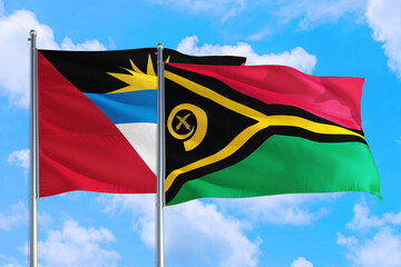 Vanuatu and Antigua and Barbuda national flag waving in the windy deep blue sky. Diplomacy and international relations concept.