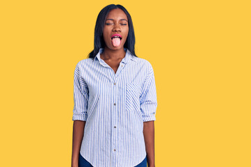 Young african american woman wearing casual clothes sticking tongue out happy with funny expression. emotion concept.