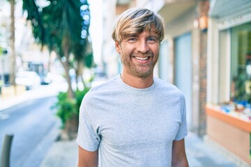 Young irish man smiling happy walking at street of city.