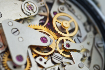 Golden gears in an iron mechanism. Macro. The concept of Time, Teamwork, Idea Technology, Infinity, Success, Business