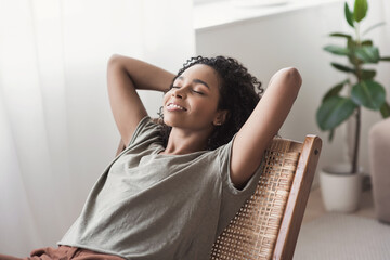 Young woman relaxing at home.  African american girl resting in her room. Enjoy life, rest, relaxation, wellbeing, lifestyle, people, recreation concept - obrazy, fototapety, plakaty