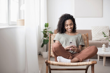 Woman using smartphone at home. Beautidul girl texting on mobile phone in her room. Communication, home work or study, lockdown, connection, mobile apps, technology, lifestyle concept